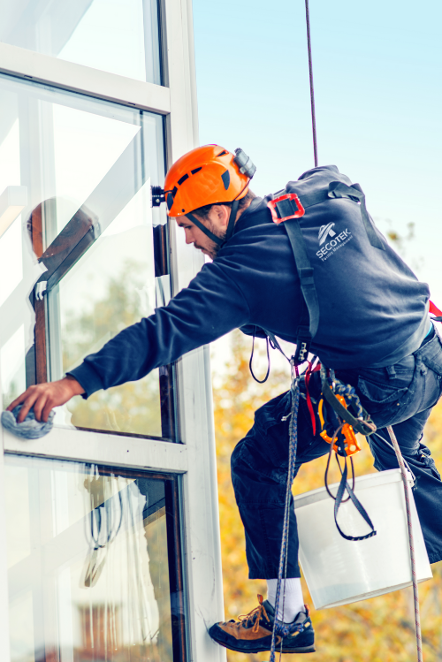 Ein Man reinigt draußen die Fenster. Er arbeitet für Secotek, ein Facility Management firma Düsseldorf
