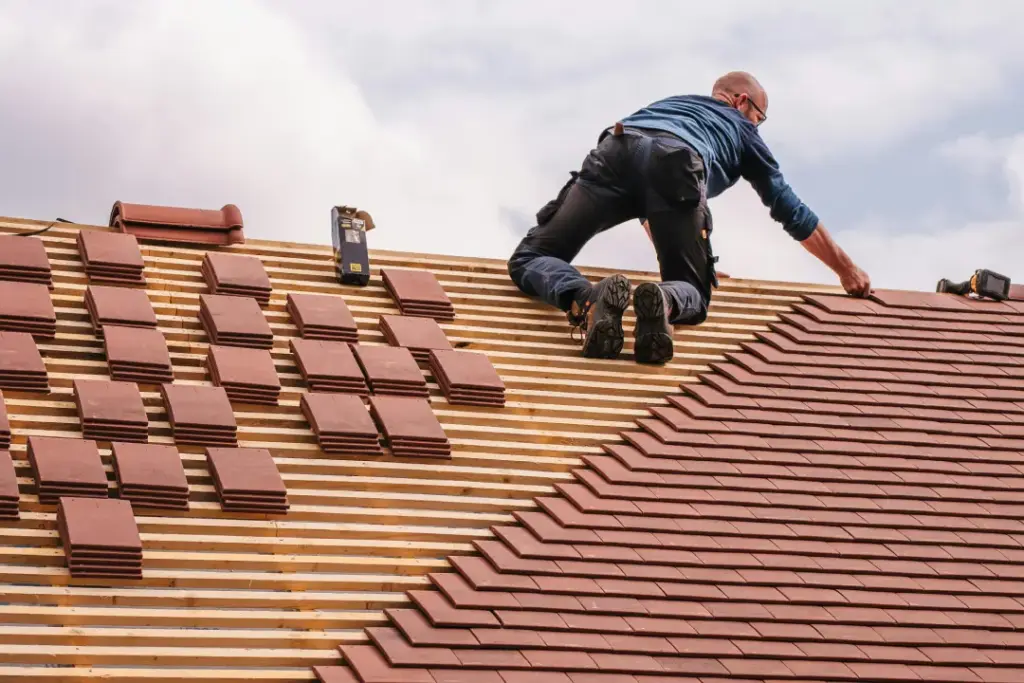 Ein Dachdecker arbeitet am Dach. Das ist unser Service: Haustechnik Düsseldorf: Dach- & Fassadentechnik